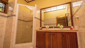 Ein Badezimmer mit Dusche, Waschbecken und Spiegel.