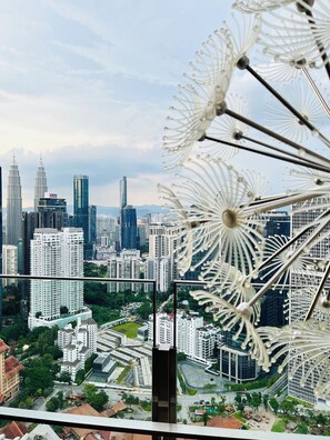 A cityscape with modern high-rise buildings, including a prominent tower with a distinctive spire. - AGILE Residences by Luna (Kuala Lumpur)