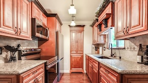A kitchen with wooden cabinets, granite countertops, stainless steel appliances, and a central island. - Home w/ Decks & River Access in Mt Gilead! (Mt Gilead)