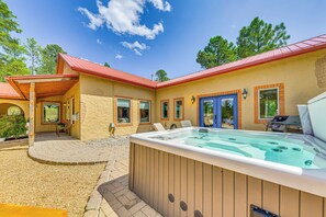 A hot tub in front of a house with a red roof and beige walls. - Ruidoso Retreat w/ Hot Tub & Patio! (Ruidoso)