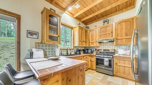 Une cuisine avec des meubles en bois, un réfrigérateur en acier inoxydable et un dosseret carrelé.