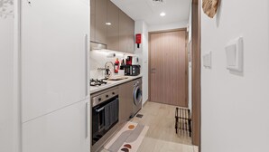 Una cocina compacta con electrodomésticos modernos, lavadora y microondas.