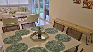 Uma sala de jantar moderna com uma mesa grande, cadeiras e pratos decorativos.