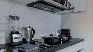 A kitchen with a blender, coffee maker, kettle, and a pot on the counter. - Capitalia | Private Patio – Peaceful Polanco Stay (Ciudad de México)
