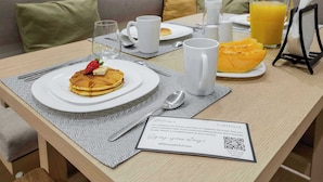 Een ontbijtje met pannenkoeken, een glas jus d'orange en een welkomstkaart.