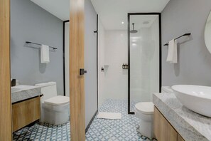 A modern bathroom with a shower, two toilets, and a large sink. - Capitalia | Condesa Glow with Gym & Balcony (Ciudad de México)