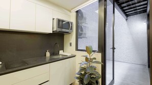 A modern kitchen with a microwave, sink, and potted plant. - Capitalia Aristoteles Polanco (Ciudad de México)