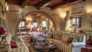 A cozy living room with a fireplace, comfortable seating, and a dining area. - Villa Saffo: A charming three-story villa surrounded by meadows and by green hills, with Free WI-FI. (Bucine)
