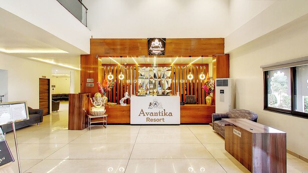 Zona de recepción en Avantika Resort, con mostrador de recepción, área de estar y señalización que indica la ubicación del mostrador de turismo.