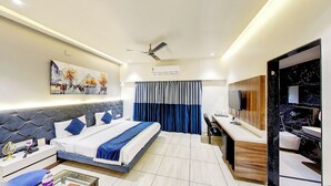 Una habitación de hotel moderna con una cama grande, un escritorio, un televisor y un baño.