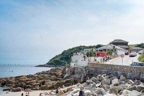 Un hotel frente al mar con costa rocosa, una playa y vistas al océano.