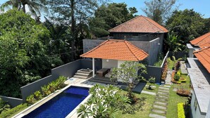 Una proprietà residenziale con piscina, patio coperto e giardino curato.