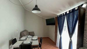 A dining area with a table set for four, a ceiling fan, and a TV mounted on the wall. - beb dragonara (Torremaggiore)