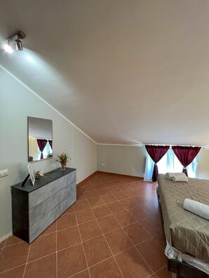 A bedroom with a bed, a dresser, a mirror, and a window with curtains. - beb dragonara (Torremaggiore)