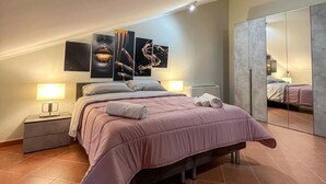 A modern bedroom with a bed, nightstands, a large mirror, and artwork on the wall. - beb dragonara (Torremaggiore)