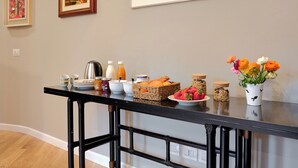 Eine Küchenarbeitsfläche mit Frühstücksgebäck, gerahmten Bildern und einem Blumenstrauß.