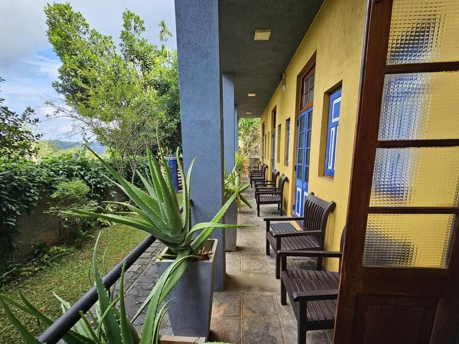 A corridor with benches, a potted plant, and a door with a textured glass panel.