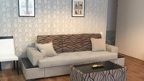 En moderne stue med tapet, en sofa, et sofabord og en bænk.