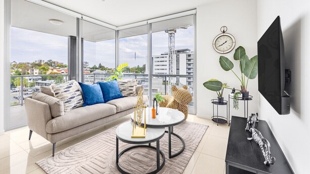 A modern living room with a sofa, coffee table, and TV.
