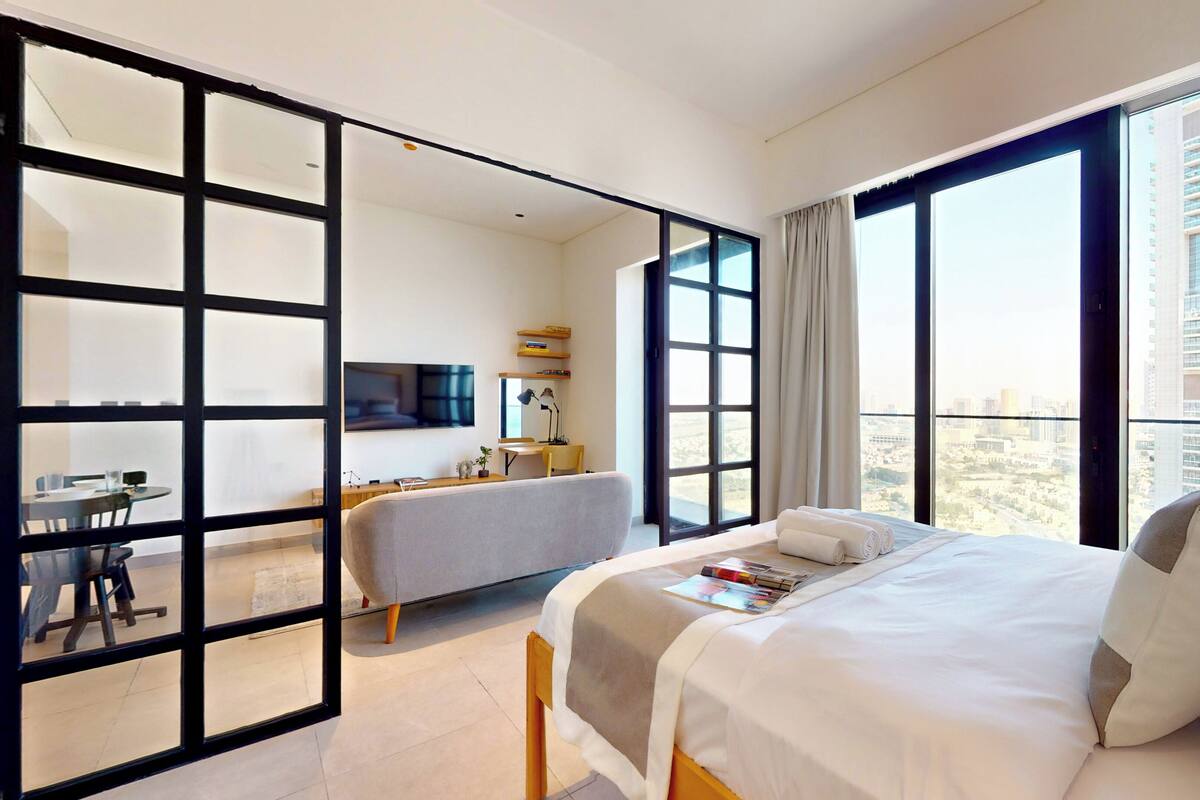 Une chambre d’hôtel moderne équipée d’un grand lit, d’un bureau, d’une chaise et d’un téléviseur.