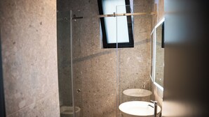 A bathroom with a glass-enclosed shower, a sink, and a mirror. - Center Boutique Hotel (Tirana)