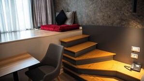 A modern room with a desk, chair, and a red sofa by a window with sheer curtains. - Center Boutique Hotel (Tirana)