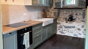 A kitchen with a stone wall, a window, and a coffee maker on the counter. - Authentic, rustic farmhouse in the heart of the Ariege Pyrenees (Saint-Lizier)