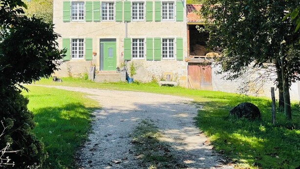 A two-story building with a tiled roof, green shutters, and a gravel path leading to the entrance. - Authentic, rustic farmhouse in the heart of the Ariege Pyrenees (Saint-Lizier)