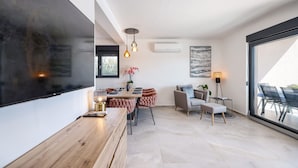 A modern interior with a dining area, a sofa, and a large window. - Villa Mindula (Sukosan)