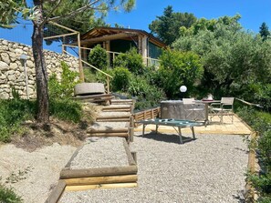 A wooden staircase leading to a covered outdoor area with a table and chairs. - Stunning  villa with hot tub, private pool, WIFI, A/C, patio, pets allowed and panoramic view (Città Sant'angelo)