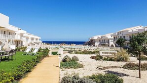A resort with multiple white buildings, a pool area, and a clear view of the ocean. - Lovely apartment for 4 guests with WIFI, pool, A/C, TV and terrace (Pachino)