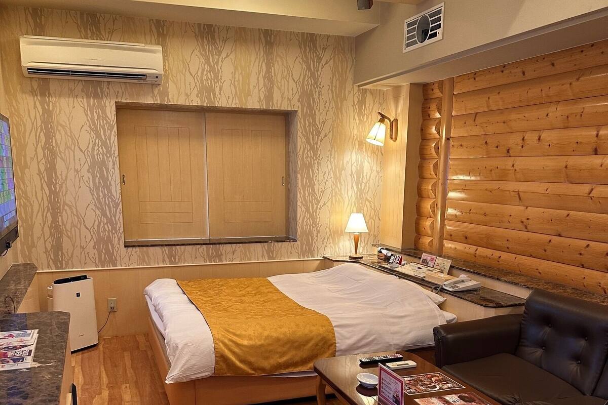 Ein Hotelzimmer mit Bett, einer Couch, einem kleinen Tisch und einem Fernseher.