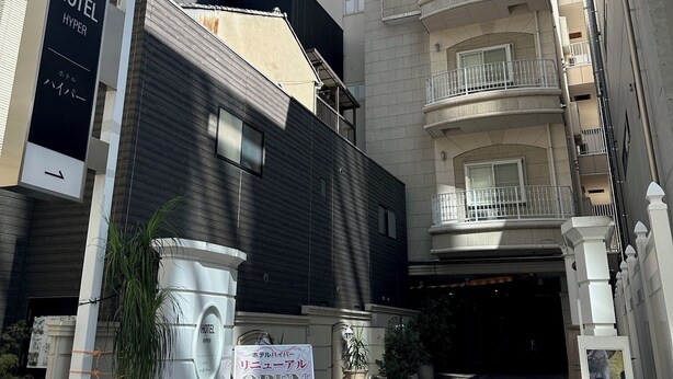 A hotel entrance with a sign indicating it's open.