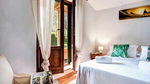 A bedroom with a bed, a nightstand, a lamp, and a painting on the wall. - Villa Sorrentina With Panoramic Terrace (Massa Lubrense)