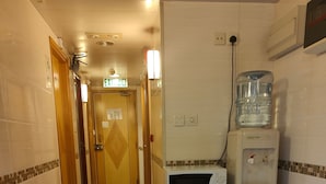 A hotel corridor with a microwave, water dispenser, and trash bin. - HONG KONG SUN GUEST HOUSE (Kowloon)