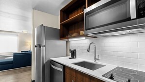 Una cocina moderna con electrodomésticos de acero inoxidable, microondas integrado y una encimera elegante.