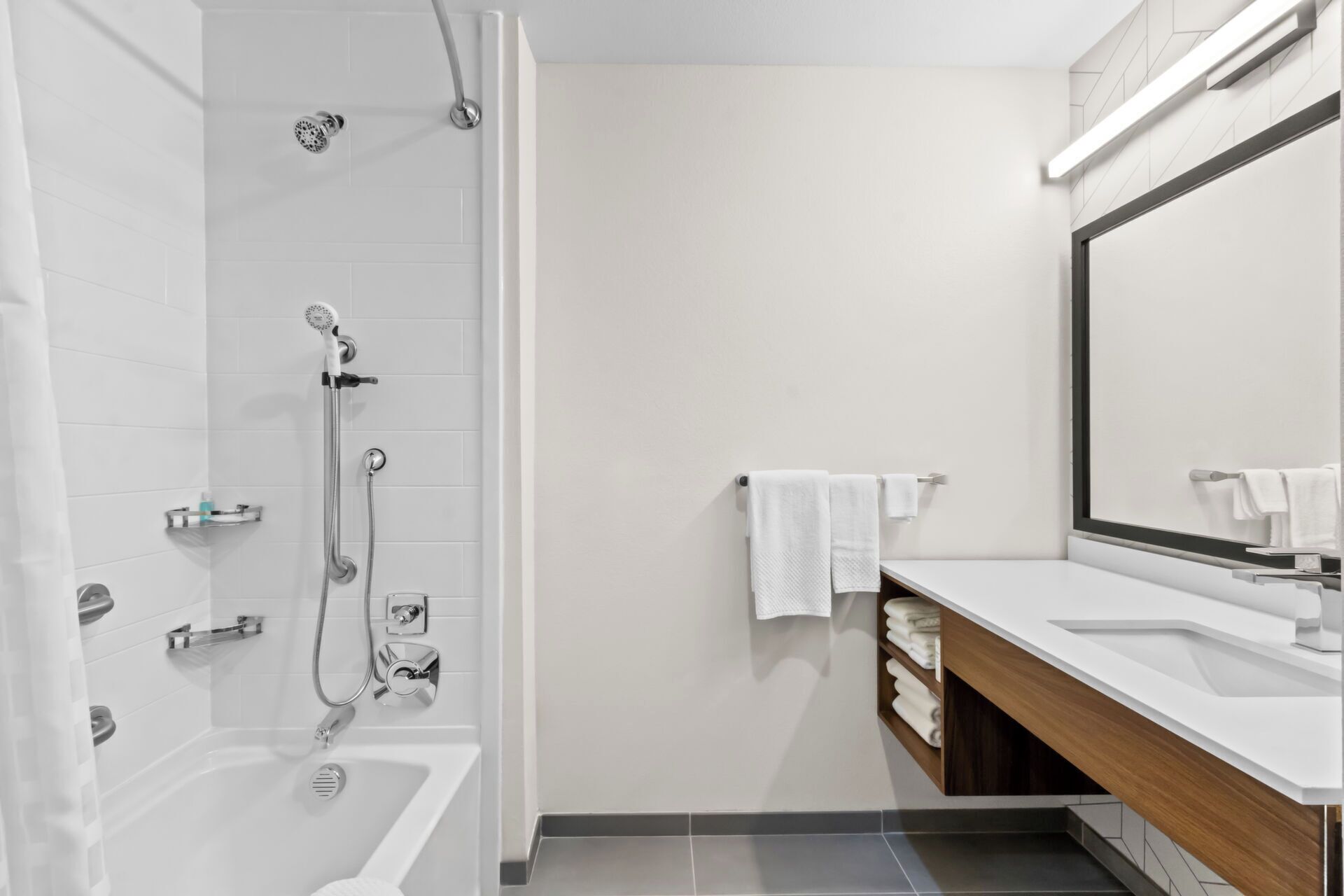 Une salle de bain moderne équipée d’une douche, d’une baignoire et d’un meuble-lavabo avec un miroir.