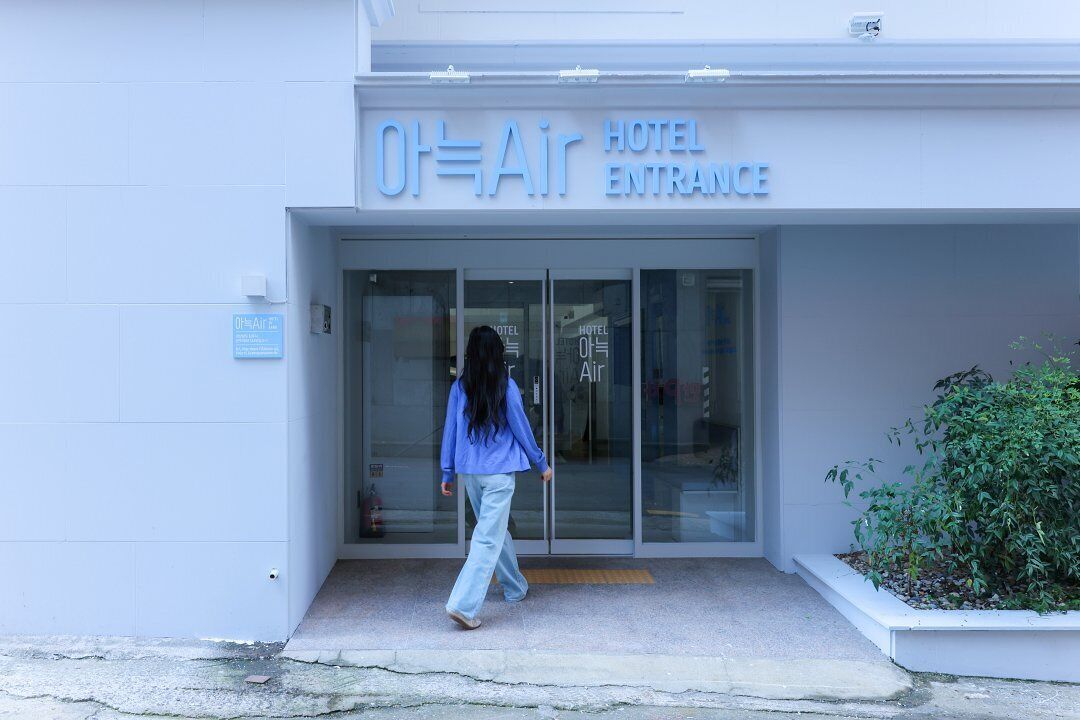 The entrance to a hotel with a glass door and a sign reading "Air Hotel Entrance".
