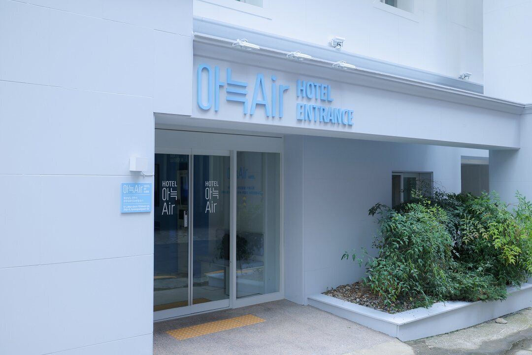 The entrance of a hotel with a sign reading "Oh-Air Hotel Entrance" and a sign in Korean.