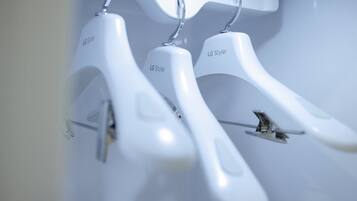 White plastic hangers labeled "LG Styler" on a wall.