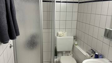 Ein Badezimmer mit Duschkabine, Toilette und Waschbecken.