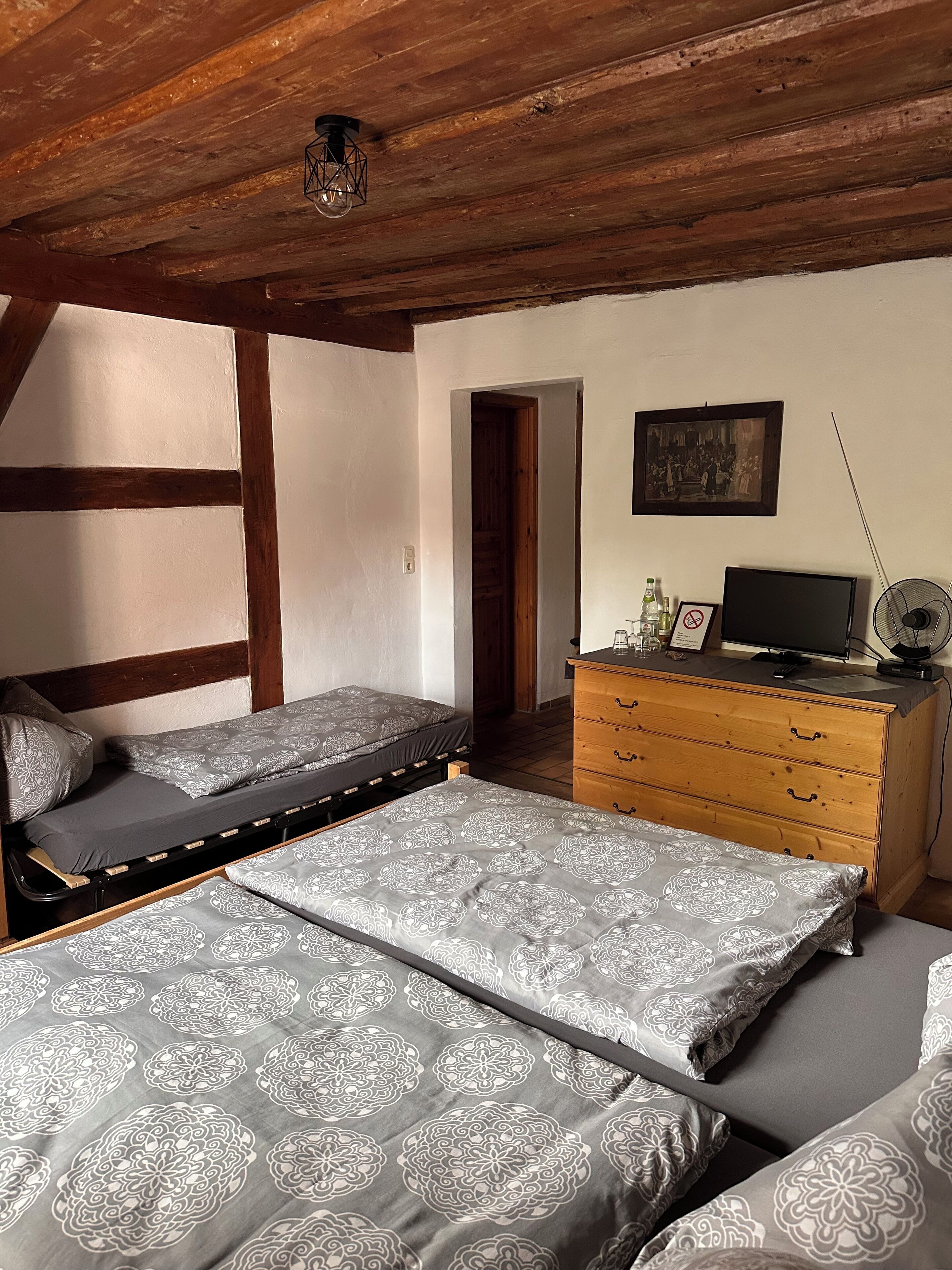 Ein Schlafzimmer mit Schlafkoje, einem Schminktisch, einem Fernseher und einem gerahmten Bild an der Wand.