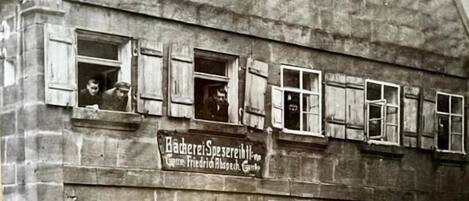 Un edificio histórico con múltiples ventanas y un letrero que dice 'Bäckerie Spezereihn'.