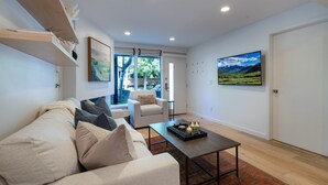 A modern living room with a sofa, coffee table, and artwork on the walls.