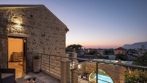A stone building with a balcony overlooking a swimming pool. - D'Oro Villas (Kissamos)