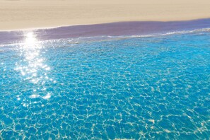 A beach with clear blue water and a sandy shore. - Gourmet in Grau i Platja (Gandia)