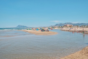 A beach with people, tents, and a mountain in the background. - River in Daim s With 2 Bedrooms and 1 Bathrooms (Daimuz)