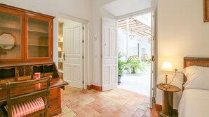 A hotel room with a wooden desk, a chair, a bedside table with a lamp, and a bed. - Posada De La Casa Del Pintor Hab C diz (Carmona)