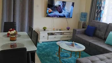 Leilighet – classic, balkong, byutsikt | Oppholdsområde | En 24-tommers smart-TV med digitale kanaler