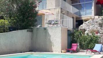 A swimming pool with a view of a building with balconies and a satellite dish.